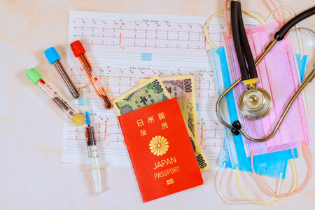 Health care in Japan is extremely expensive, with stethoscopes on heart electrocardiograms, Japanese yen, Japanese passport requiredの写真素材