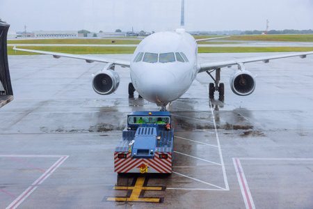Preparations for departure airplanes are rolled out of terminal gates during rainy weatherの写真素材