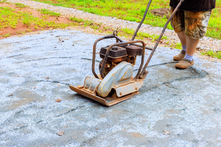 Compaction of sand by vibratory tamping machine during construction of pool platform
