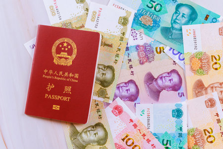 Authentic passport of People Republic of China containing Chinese cash yuan banknotes various denominationsの写真素材
