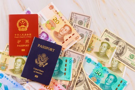 It symbolizes confrontation between economies of China, United States when authentic passports are presented with Chinese currency, yuan, US dollars banknotes various denominations.の写真素材