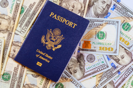 An American passport on top American dollar cash banknote of different denominationの写真素材