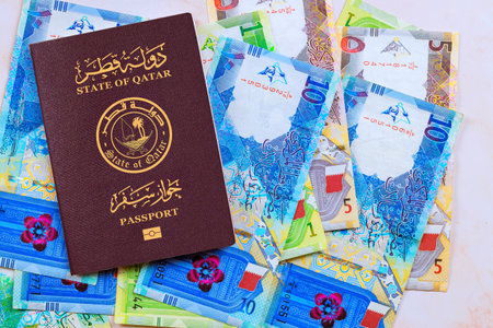 Passport issued by State of Qatar with Qatari banknotes in currency Riyals in cash of various...