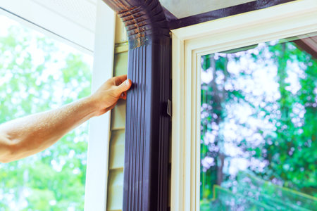 It is handyman assembling gutter channels that will be attached to roof.の写真素材