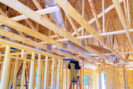 During construction, silver insulation ventilation HVAC pipes were installed from ceiling to roofの写真素材