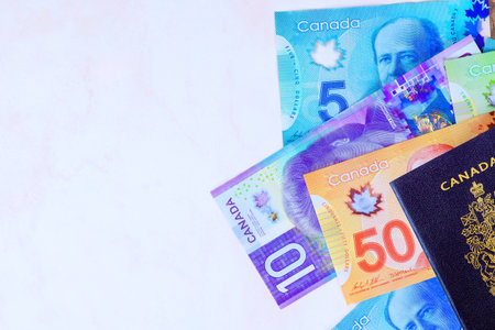 Passport issued by Canadian government with Canada banknotes in currency dollars in cash of various denominationsの写真素材
