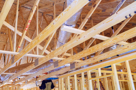 Installing silver insulation ventilation HVAC pipes during constructionの写真素材