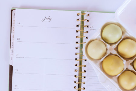 There in carton eggs resting on an open notepad as part of baking process