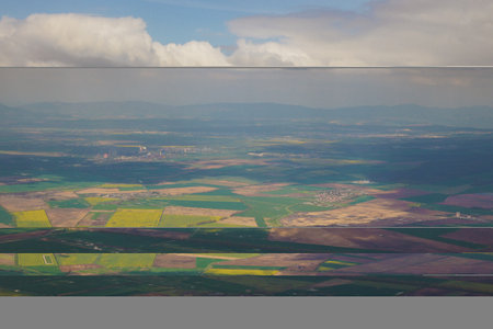 This captures a stunning aerial view of expansive farmland featuring vibrant green, yellow, and...
