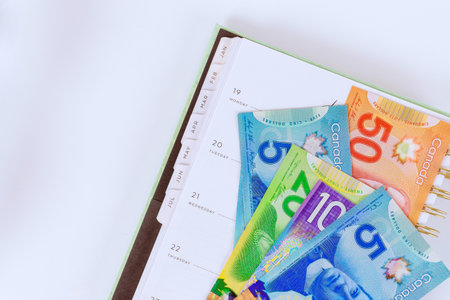 In order to plan financial future, Canadian dollar banknotes cash bills are collected placed in calendar planner.の写真素材