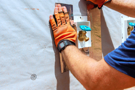 Skilled worker applies insulation material to an exterior wall, showcasing attention to detail...