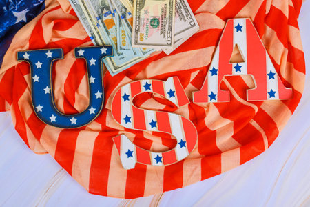 USA letters sit top striped fabric with dollar bills, symbolizing patriotism finance celebration.の写真素材