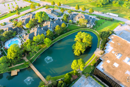 Panoramic view showcasing tranquil pond surrounded by lush greenery, nearby residential buildings in Sayreville New Jerseyの写真素材