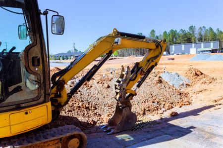 Heavy excavator machinery is actively digging into ground at construction site