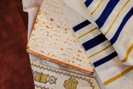 Matzah rests atop beautifully designed tallit prayer shawl, symbolizing traditions during Passover holiday.の写真素材