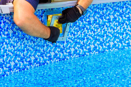Craftsman carefully installs new pool filtration system over liner at home backyardの写真素材