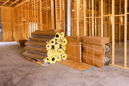 Insulation materials are neatly stacked on concrete floor within construction site undergoing renovation work.の写真素材