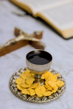 Communion elements including wine bread are thoughtfully arranged on silver tray, creating peaceful atmosphere in churchの写真素材