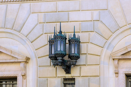 Vintage street lamp adorns wall of historical building, illustrating beautiful architectural design elegance.の写真素材