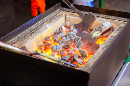 Blacksmith charcoal with glowing coals embers is during axe makingの写真素材