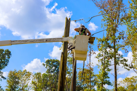 Technician repairs power lines from bucket lift after hurricaneの写真素材