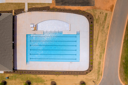 Families gather around spacious pool for relaxation fun under bright day summer timeの写真素材