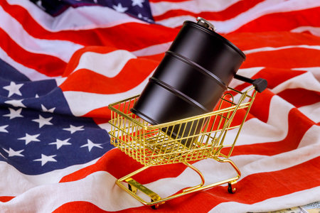 Golden shopping cart holds black barrel top vibrant American flagの写真素材