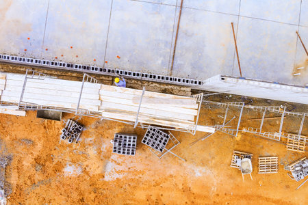 Construction crews are working on building, arranging materials scaffolding in an urban construction site.の写真素材