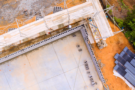 Workers are constructing building foundations with scaffolding materials at construction site in day hoursの写真素材