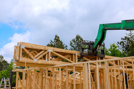 Workers use crane to lift timber truss beams for new structure under works day