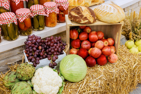 Baskets apples, grapes, vegetables alongside loaves of bread in cozy market full seasonal delights.の写真素材