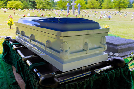 Casket is displayed in cemetery surrounded by blooming flowers gravestonesの写真素材
