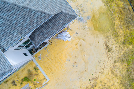 Aerial view of construction site showing debris cleared land next to structure in progress.の写真素材