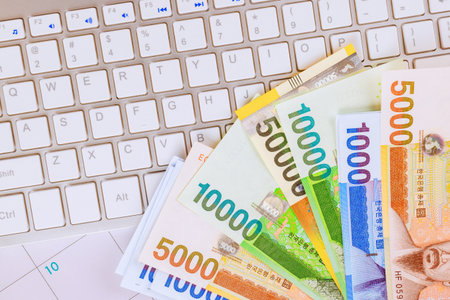 South Korean won money bills currency notes spread across keyboard, symbolizing online banking financial activitiesの写真素材