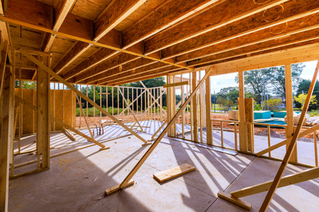 Wooden framing is being constructed, support beams of building materials in an active building site.