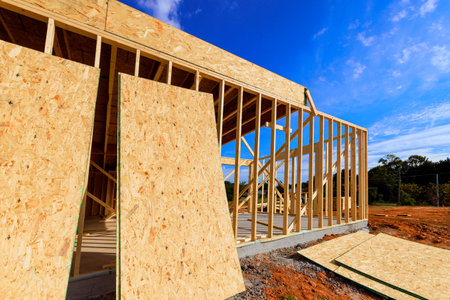 Workers are building is beams framework wooden house with large plywood panels in under works day