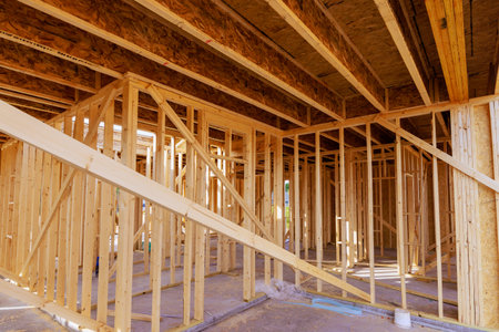 Workers are framing new home, showcasing wooden structures beams open spaces in construction area.