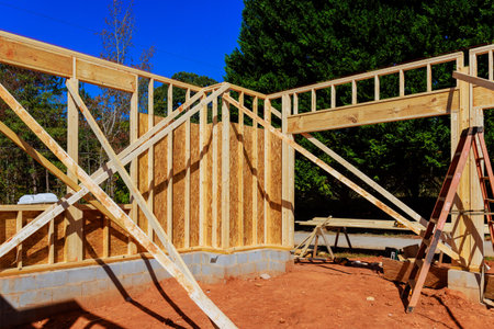 Workers are framing beams structure using wooden beams at construction site.