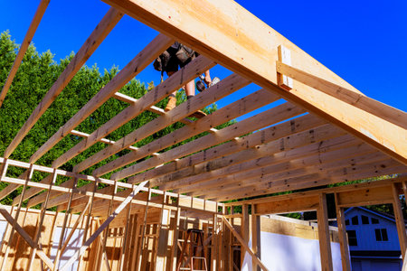 Workers are constructing wooden roof frame in residential area under framework construction