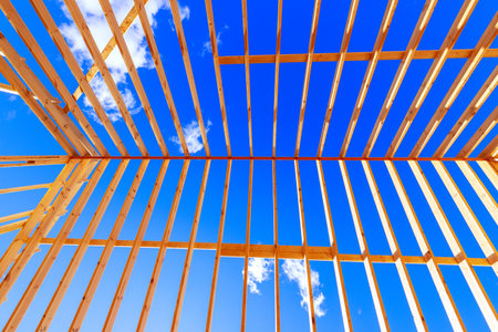 Wooden beams form structure roof frame trusses at under constructionの写真素材