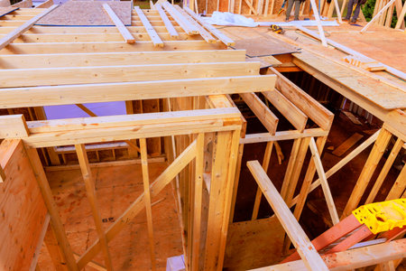 Construction workers frame joist dwelling wooden structure under building progress.