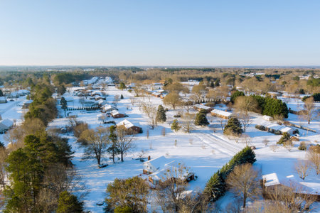Peaceful American suburban area blanketed in snow with houses under skies on winter day.の写真素材