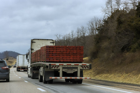 Truck loaded with wooden pallets drives on quiet American highwayの写真素材