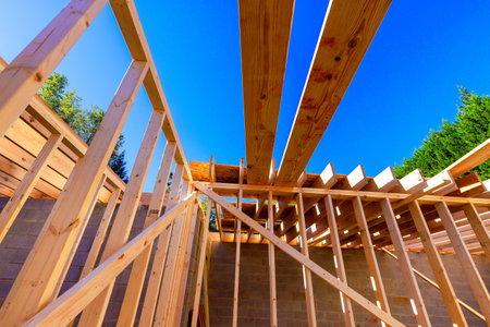 Workers are constructing wooden frame structure with beams under work day