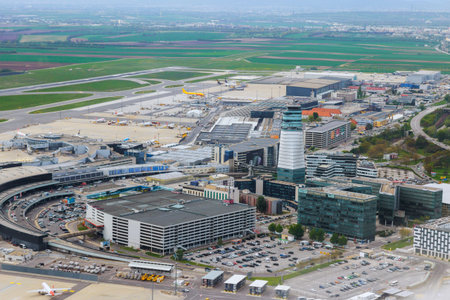 26 April 2025 Vienna, Austria An aerial view of international airport with numerous planes, terminals, green fields nearby Vienna, Austriaのeditorial素材