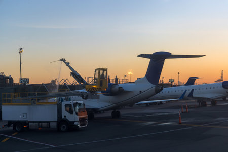 Refueling action takes place as evening light casts warm glow over busy airport terminal.