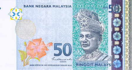 Fifty ringgit cash banknote from Malaysia figure in traditional attire with flowers designs on paper...