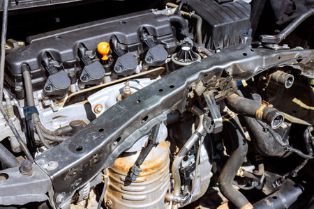 Car engine parts are exposed as mechanics work on vehicle in repair shop