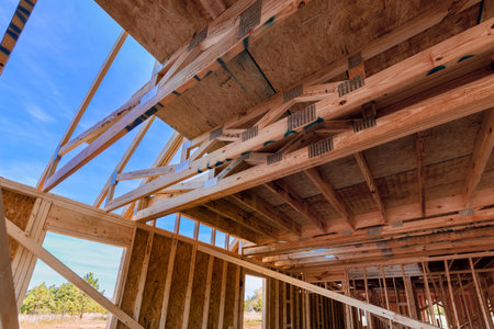 Workers frame structure using wooden beams under assemble joints trusses in an outdoor construction...