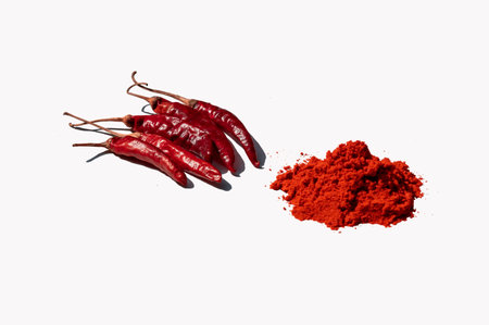 Red chili peppers and powder isolated on a white background. Selective focus.